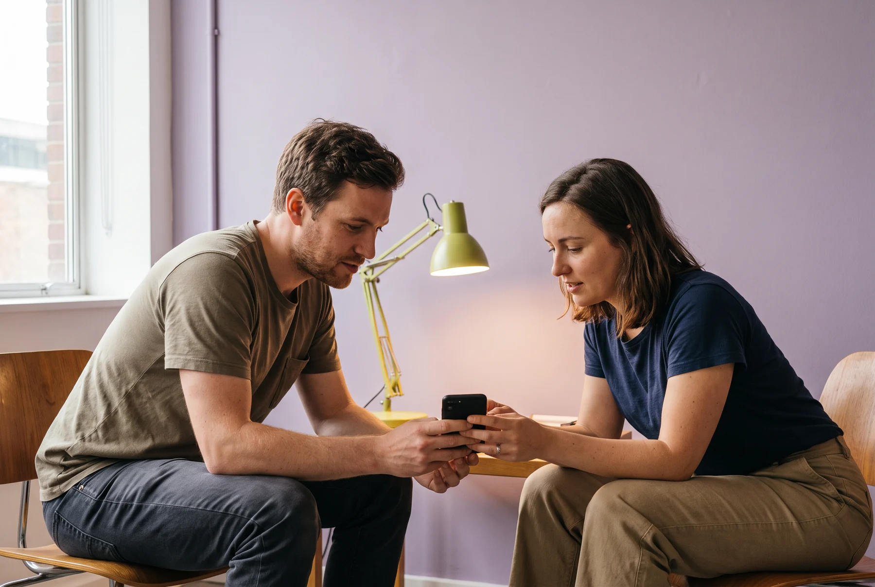 Two people examining a smartphone together
