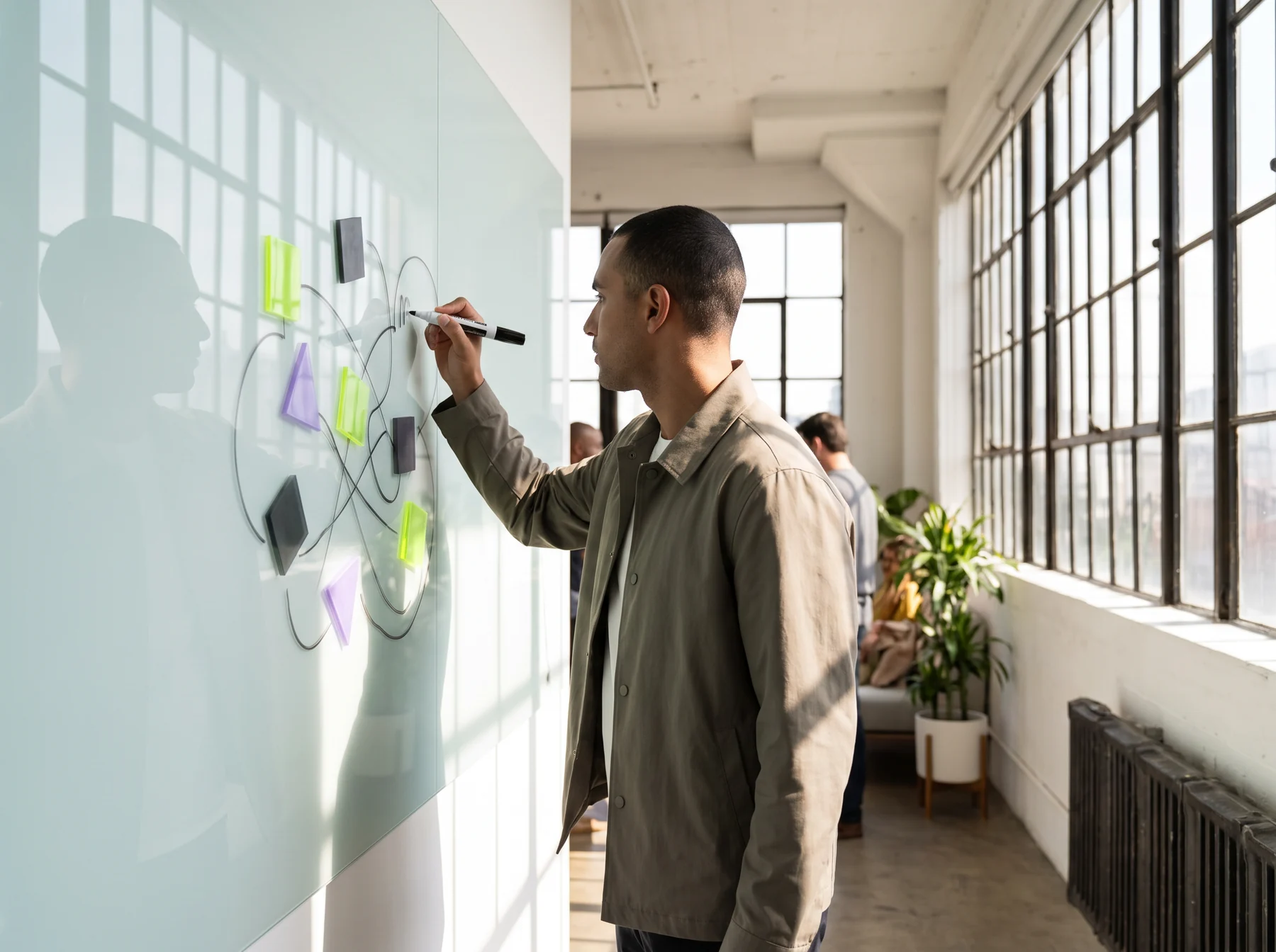 Designer placing notes on a wall during mobile product planning